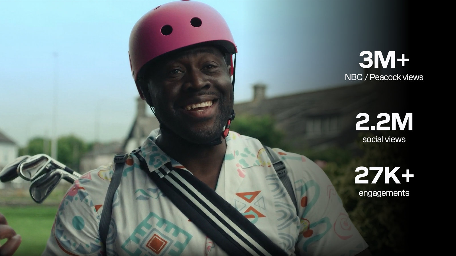 A golfer in a pink cycling helmet with his clubs slung across his back
